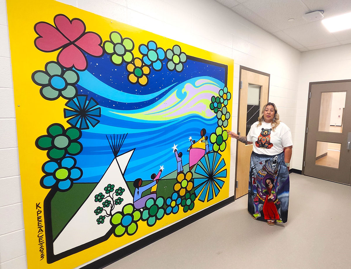 Greater Saskatoon Catholic Schools Community and Resource Development’s Ashley Petite points to a painting created by Indigenous artist Kevin Peace during a recent media tour of the new facility.